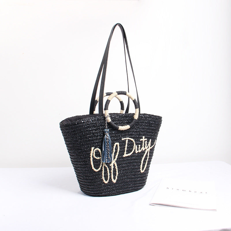 Designer Strohtasche mit verspieltem Text und dekorativem Pompon Skanto