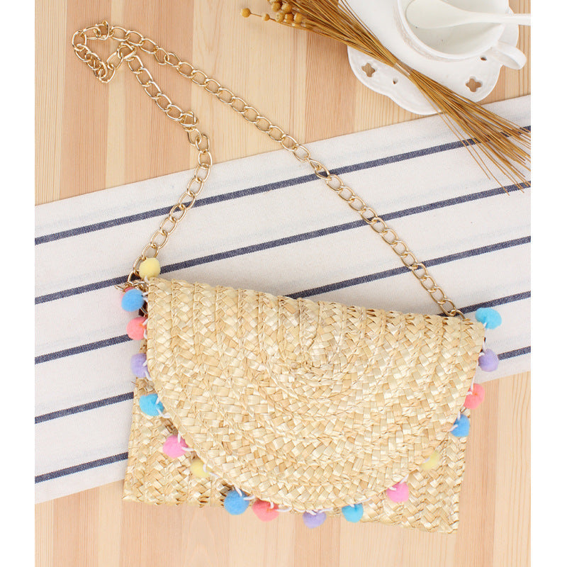 Handgewebte Raffia-Clutch mit dekorativen Pompons Skanto